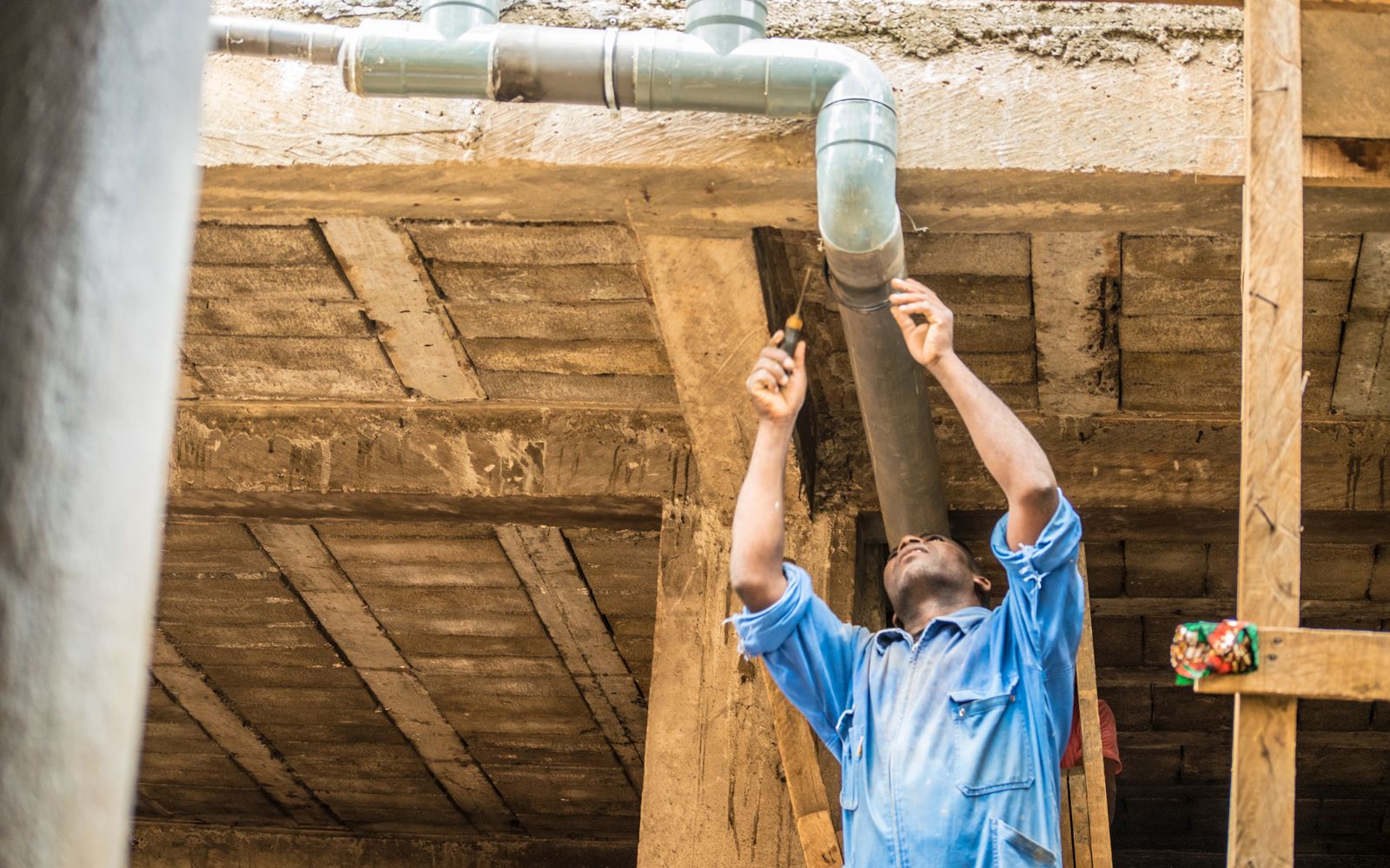 Plumber fixing a pipe overhead